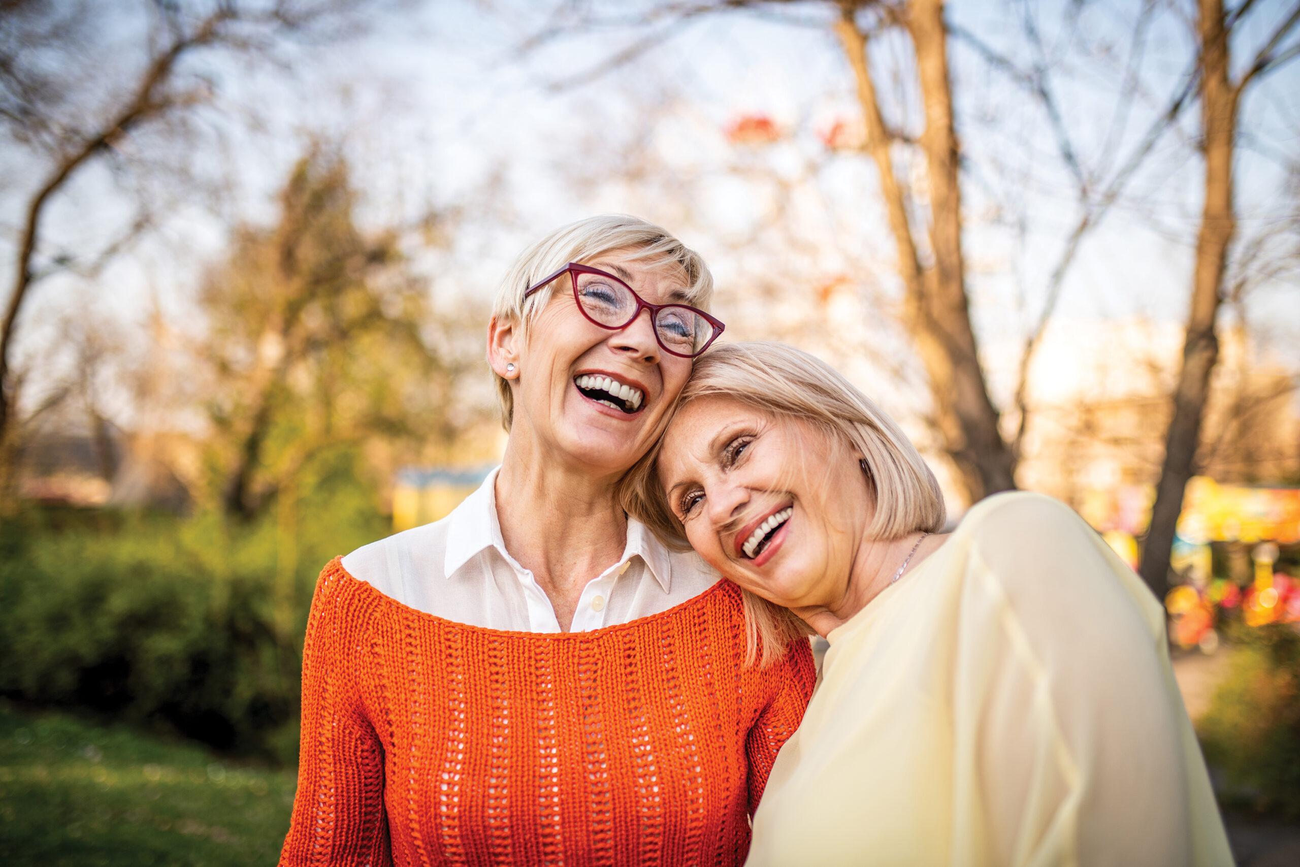 Two senior women laughing at the park