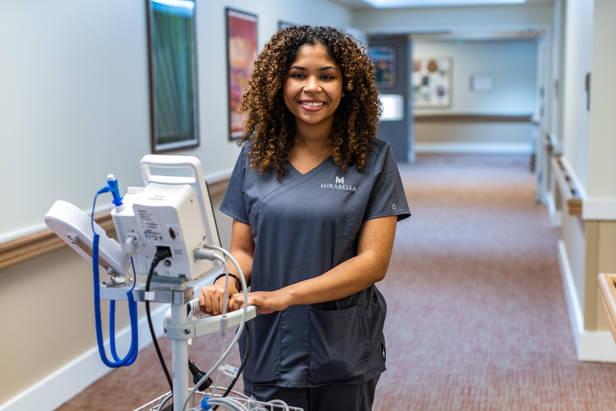 A nursing employee is pictured with a piece of equipment.